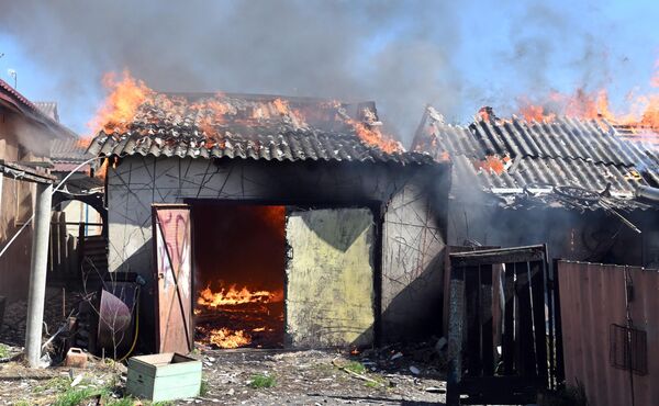 Hỏa hoạn xảy ra tại các tòa nhà do máy bay không người lái bắn phá ở làng Tavolzhanka, tỉnh Kharkov - Sputnik Việt Nam