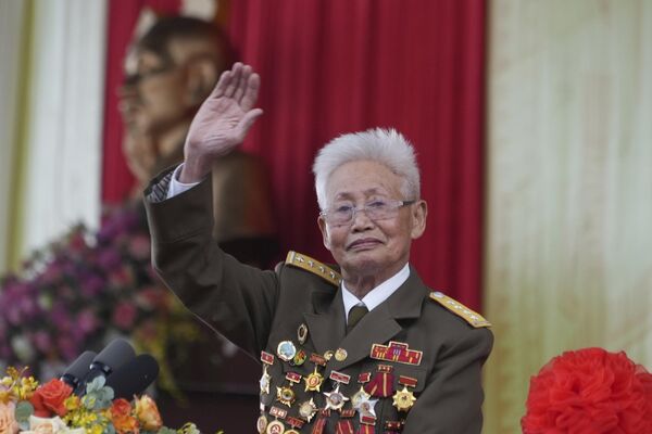 Cựu chiến binh Phạm Duy Cử vẫy tay chào mọi người trong cuộc diễu hành kỷ niệm chiến thắng ở Điện Biên Phủ, Việt Nam - Sputnik Việt Nam