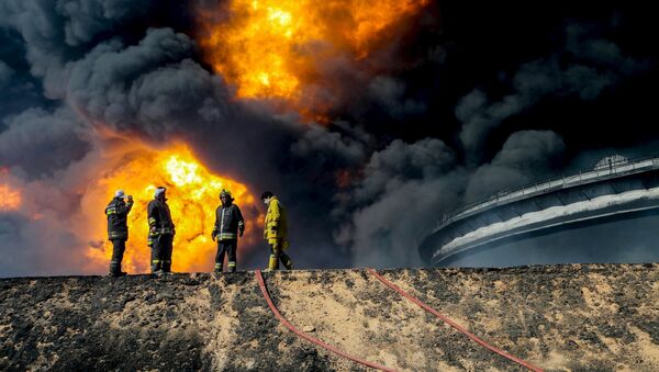 Xe cứu hỏa trên nền kho chứa dầu bốc cháy tại thành phố Ras Lanuf ở Libya - Sputnik Việt Nam