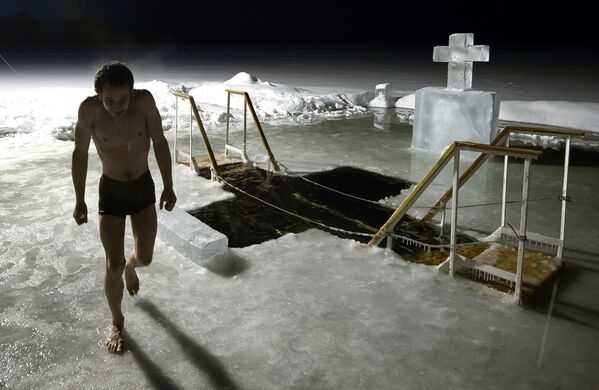 Người đàn ông tắm hố băng trong hồ của tu viện Iversky Svyatoozer, Valdai. - Sputnik Việt Nam