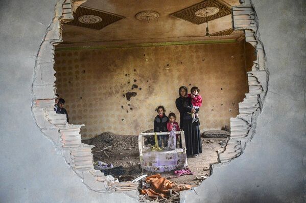 Người phụ nữ cùng đứa con trong ngôi nhà bị phá hủy, Silopi, Thổ Nhĩ Kỳ. - Sputnik Việt Nam