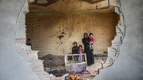 Người phụ nữ cùng đứa con trong ngôi nhà bị phá hủy, Silopi, Thổ Nhĩ Kỳ. - Sputnik Việt Nam