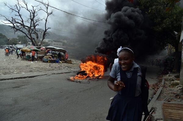 Cô gái bên những chiếc lốp xe bị đốt cháy trong cuộc biểu tình ở Haiti - Sputnik Việt Nam