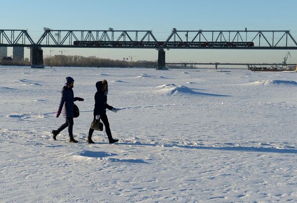 Người dân thành phố đi dạo trên con sông đã đóng băng gần cầu đường sắt bắc qua sông Ob ở Novosibirsk - Sputnik Việt Nam