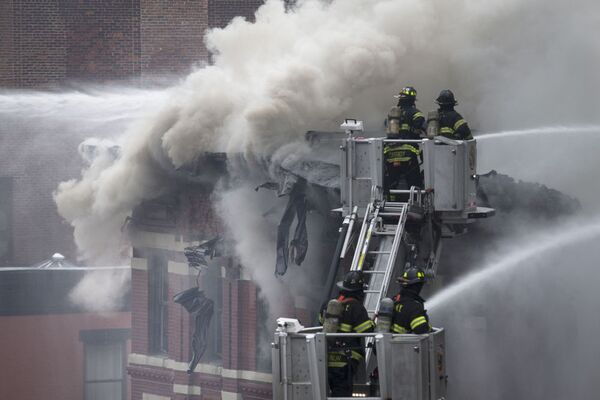 Nhân viên cứu hỏa dập đám cháy trong tòa nhà ở New York, nơi xảy ra vụ nổ khí gas - Sputnik Việt Nam