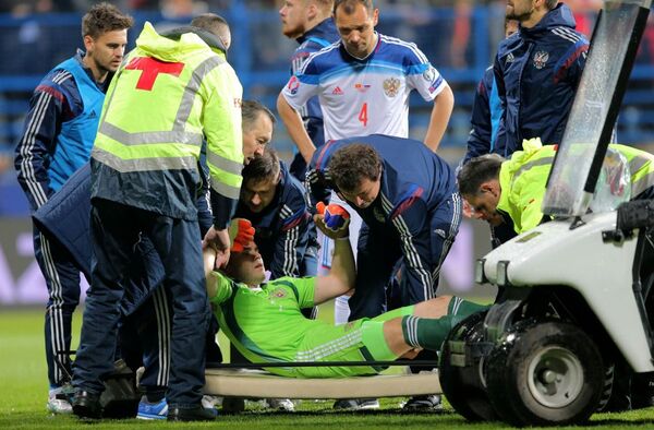 Thủ môn Nga Igor Akinfeev, bị thương trong trận đấu vòng loại Giải vô địch bóng đá châu  Âu 2016 giữa đội tuyển quốc gia Montenegro và Nga, được các nhân viên y tế đưa ra khỏi sân. - Sputnik Việt Nam