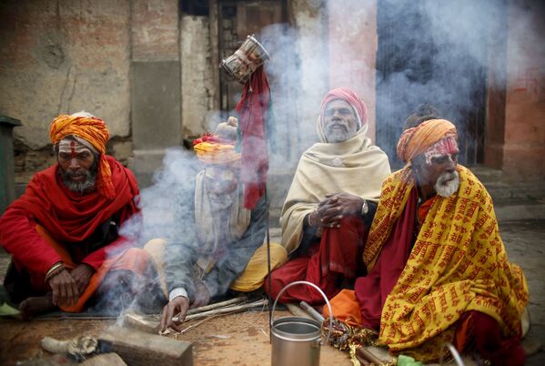 Các thánh nhân Hindu “Sadhu” ngồi bên đống lửa trong đền thờ Pashupatinath ở Kathmandu, Nepal - Sputnik Việt Nam