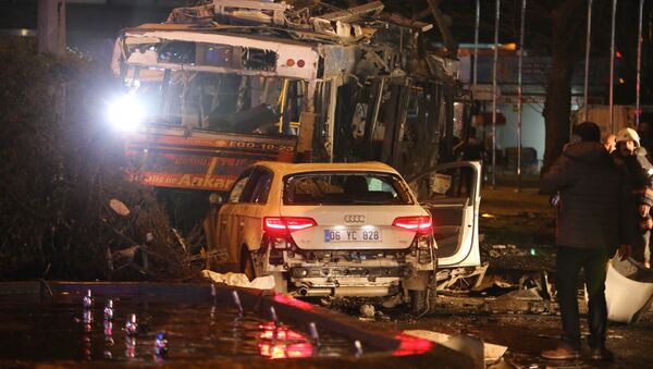 A man stands next to a burnt out bus after a blast in Ankara on March 13, 2016 - Sputnik Việt Nam