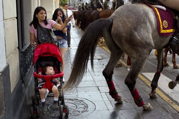 Người phụ nữ và đứa bé sau vó ngựa của cảnh sát trong cuộc trình diễn tại Lima, Peru - Sputnik Việt Nam