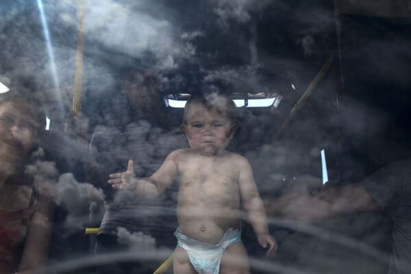 Một đứa trẻ trong xe buýt tại trạm kiểm soát biên giới Izvarino tỉnh Lugansk - Sputnik Việt Nam