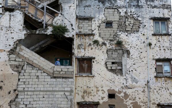 Cậu bé đứng trên cầu thang tòa nhà bị phá hủy ở Lebanon - Sputnik Việt Nam