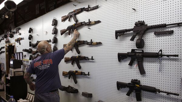 Người Mỹ buôn bán vũ khí đứng bên tại quầy với khẩu súng Kalashnikov - Sputnik Việt Nam