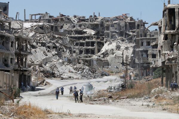 Công nhân thu thập các mảnh vỡ của tòa nhà bị hư hỏng để tái thiết  thành phố Homs của Syria - Sputnik Việt Nam