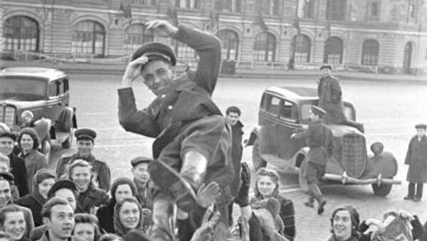 Dân chúng Moskva tung hô người sĩ quan trên Quảng trường Đỏ trong ngày Chiến thắng 9 tháng 5 năm 1945. - Sputnik Việt Nam