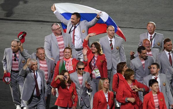 Đại diện phái đoàn Belarus Andrei Fomochkin với lá cờ Nga trong cuộc diễu hành của các vận động viên và thành viên phái đoàn quốc gia tại lễ khai mạc TVH Paralympic XV - 2016 ở Rio de Janeiro - Sputnik Việt Nam