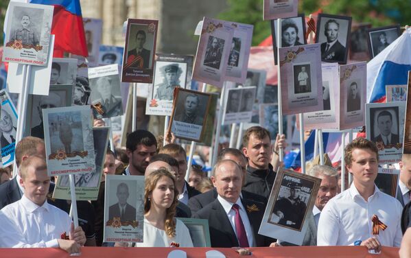 Tổng thống Nga Vladimir Putin với bức chân dung của thân phụ là cựu chiến binh mặt trận Vladimir Spiridonovich tham gia cuộc diễu hành yêu nước Trung đoàn Bất tử trên Quảng trường Đỏ - Sputnik Việt Nam