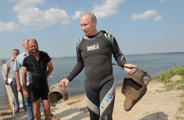 Thủ tướng Nga Vladimir Putin (phải) mặc đồ lặn, trên tay cầm hai bình gốm cổ mà ông tìm thấy dưới đáy Vịnh Taman, nơi ông lặn xuống với thiết bị dưỡng khí  để xem “Atlantis của Nga” – phần bị đắm dưới đáy biển của thành phố cổ đại Phanagoria. - Sputnik Việt Nam