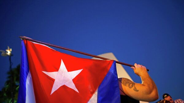 An anti-Castro Cuban exile holds a Cuban flag during a protest after the announcement of restoring diplomatic ties between Cuba and United States, at an area knows as 'Little Havana' in downtown Miami, Florida December 17, 2014. - Sputnik Việt Nam