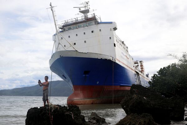 26 tháng 12. Philippines. Chụp ảnh “tự sướng” trên nền chiếc tàu phà bị mắc kẹt trong cơn bão Nock-Ten. - Sputnik Việt Nam