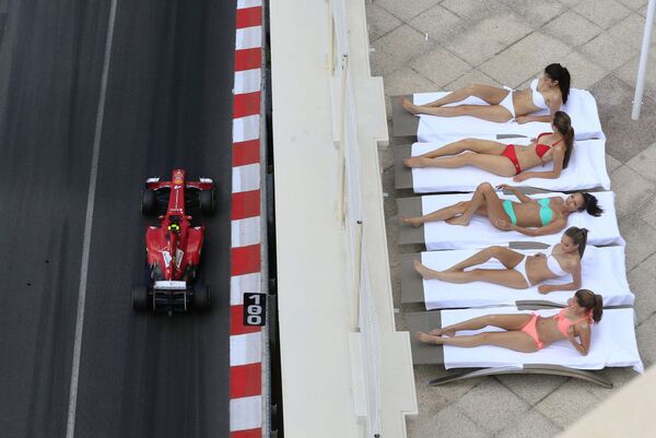 Tay đua người Brazil Felipe Massa lái chiếc Ferrari ngang qua các cô gái tắm nắng trên tuyến đường phố Monte Carlo trước thềm Grand Prix Monaco - Sputnik Việt Nam