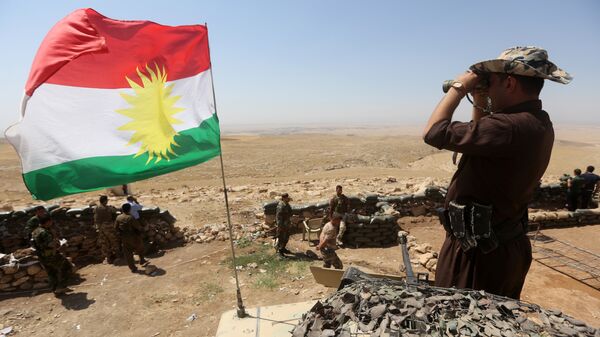 A flag of the autonomous Kurdistan region flies as Iraqi Kurdish Peshmerga fighters take position to monitor the area from their front line post in Bashiqa, a town 13 kilometres north-east of Mosul (File) - Sputnik Việt Nam