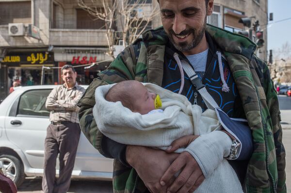 Người đàn ông với em bé trên đường phố Damascus sau khi công bố lệnh ngừng bắn - Sputnik Việt Nam