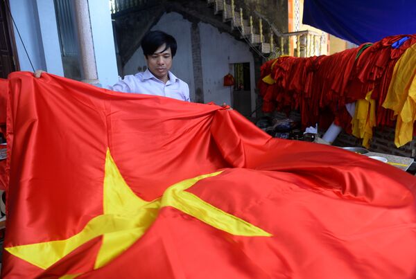 Quốc kỳ Việt Nam trong tay người thợ tại một xưởng sản xuất cờ ở Hà Nội - Sputnik Việt Nam