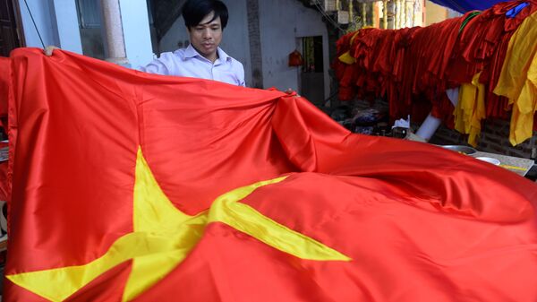 Quốc kỳ Việt Nam trong tay người thợ tại một xưởng sản xuất ở Hà Nội - Sputnik Việt Nam