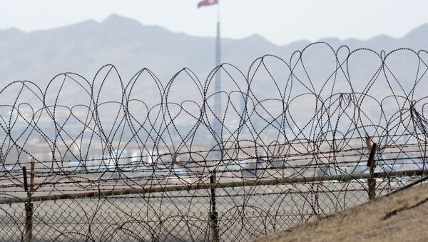 A North Korean flag behind the barbed wire of the Demilitarized Zone (DMZS) in the Joint Security Area near Panmunjom on the border between North and South Korea - Sputnik Việt Nam