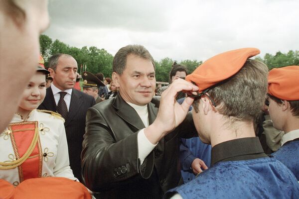 Bộ trưởng Bộ tình trạng khẩn cấp Sergei Shoigu trao thẻ chứng nhận và mũ nồi màu cam cho các thành viên tại lễ thành lập Lực lượng cứu hộ sinh viên toàn nước Nga. - Sputnik Việt Nam