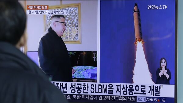 A man watches a TV news program showing photos published in North Korea's Rodong Sinmun newspaper of North Korea's Pukguksong-2 missile launch and North Korean leader Kim Jong Un at Seoul Railway Station in Seoul, South Korea, Monday, Feb. 13, 2017 - Sputnik Việt Nam