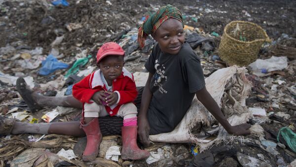 Người phụ nữ với một đứa trẻ thu nhặt rác trong bãi thải ở Nairobi, Kenya. - Sputnik Việt Nam