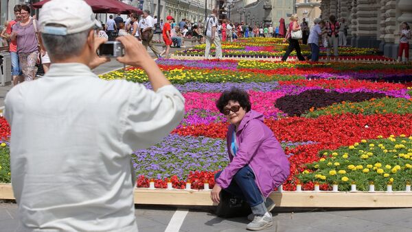 Khách du lịch chụp ảnh trên thảm hoa tại lễ hội hoa ở GUM - Sputnik Việt Nam