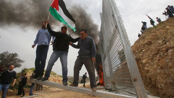 Người Palestine phá hàng rào do người Israel dựng trong cuộc biểu tình phản đối tại thành phố ở Bờ Tây sông Jordan. - Sputnik Việt Nam