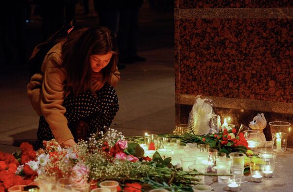 Cô gái thắp ngọn nến ở lối vào sảnh ga tàu điện ngầm Spasskaya, tưởng niệm các nạn nhân trong vụ khủng bố. - Sputnik Việt Nam