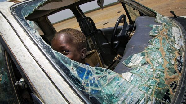 Nam Sudan. Đứa trẻ chơi đùa trong chiếc xe ô tô bị phá vỡ  vì chiến sự. - Sputnik Việt Nam