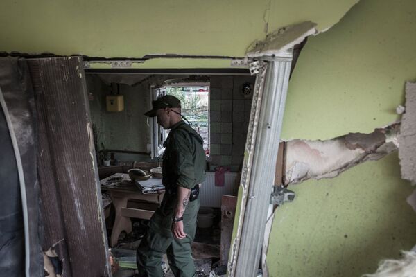 Dân quân Cộng hòa nhân dân Donetsk kiểm tra căn nhà đã bị phá hủy bởi đạn pháo do lực lượng an ninh Ukraina bắn vào Gorlovka - Sputnik Việt Nam