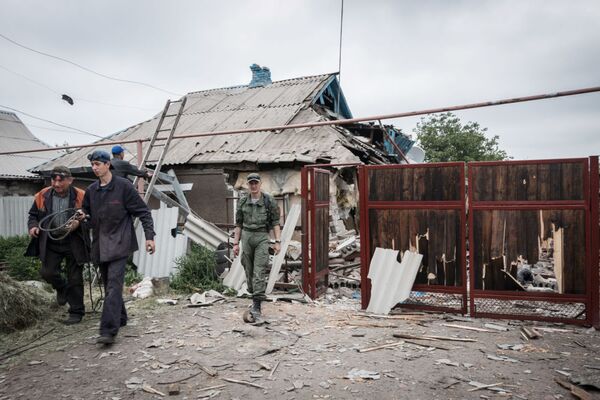 Các cư dân Donetsk tại ngôi nhà đã bị đạn pháo của lực lượng an ninh Ucraina phá hủy. - Sputnik Việt Nam