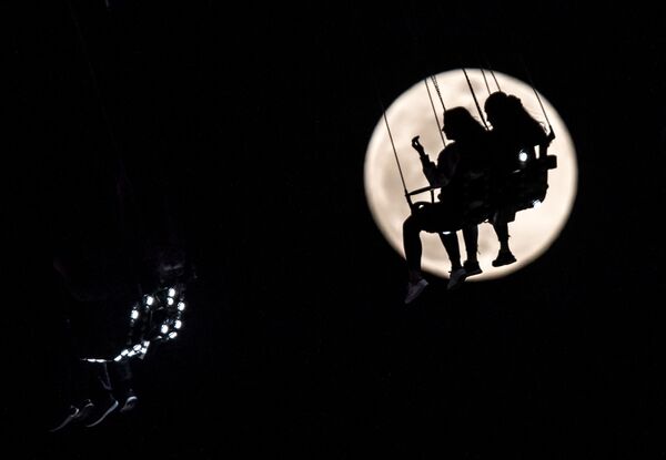 Vòng đu quay trên nền trăng tròn tại hội chợ Frankfurt-am-Main, Đức. - Sputnik Việt Nam