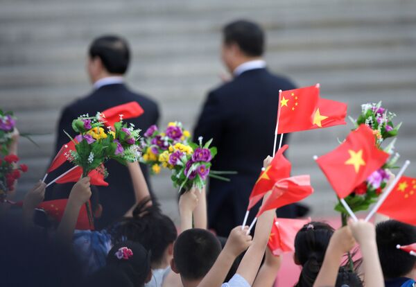Quốc kỳ Việt Nam và Trung Quốc tung bay ở Bắc Kinh trong lễ chào đón Chủ tịch Việt Nam Trần Đại Quang tại sân bay Bắc Kinh - Sputnik Việt Nam