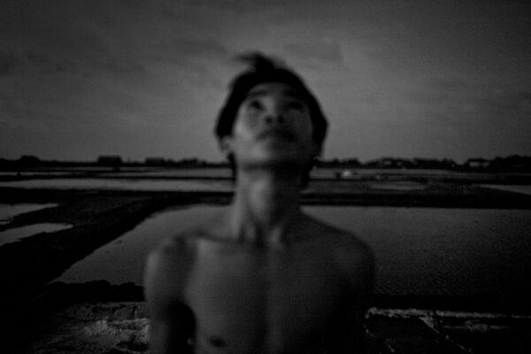 Cậu thiếu niên 16 tuổi Phong Quyen dõi nhìn bầu trời đêm đầy sao trong lúc giải lao trên đồng muối - Sputnik Việt Nam