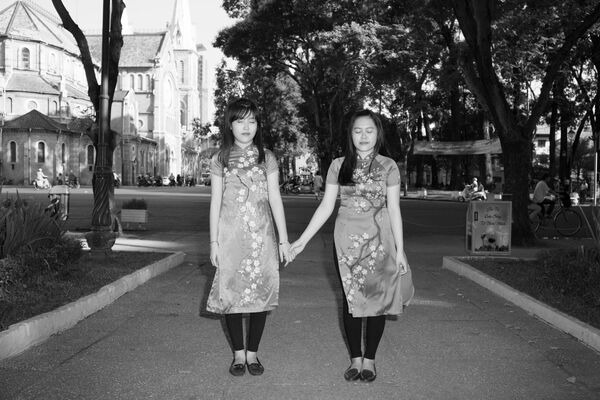 Hai chị em tạo dáng chụp hình trong trang phục truyền thống ở  một công viên Sài Gòn - Sputnik Việt Nam