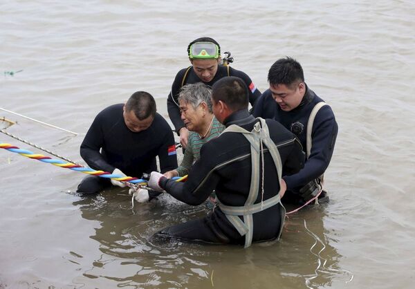Các nhân viên cứu hộ giúp một phụ nữ sau khi tàu đắm ở Trung Quốc - Sputnik Việt Nam