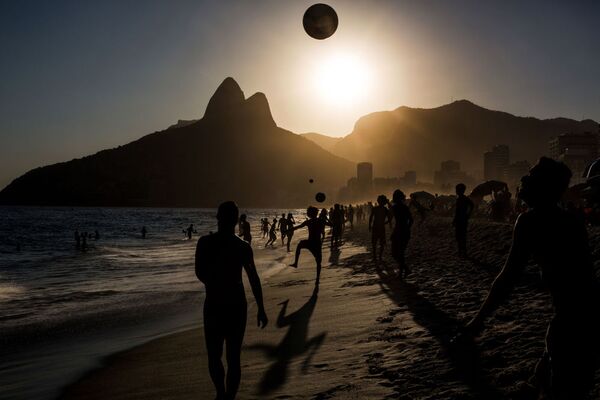 Tác phẩm của nhiếp ảnh gia Bồ Đào Nha Daniel Rodrigues «People playing soccer ball on Ipanema beach at sunset, Rio de Janeiro». Giải III trong hạng mục “Thể thao. Loạt ảnh”. - Sputnik Việt Nam