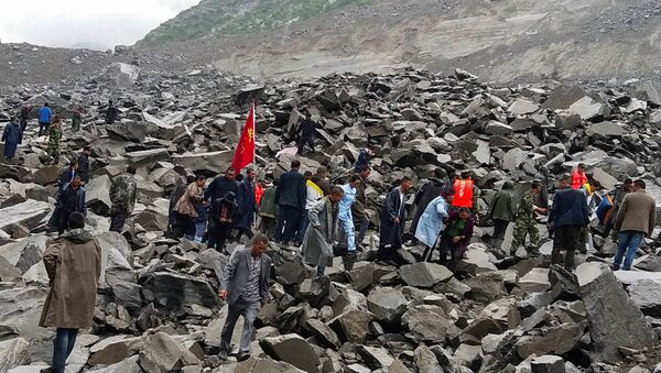People search for survivors at the site of a landslide that destroyed some 40 households, where more than 100 people are feared to be buried, according to local media reports, in Xinmo Village, China June 24, 2017. - Sputnik Việt Nam