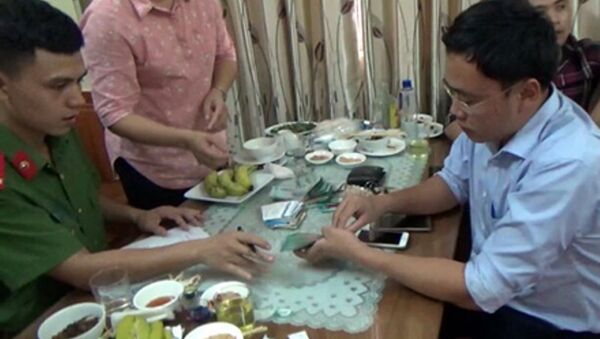 Nhà báo Lê Duy Phong (áo xanh, bên phải) bị công an bắt khi đang dùng bữa tại nhà hàng. Ông Phong được cho là có hành vi nhận tiền của doanh nghiệp tại đây. - Sputnik Việt Nam