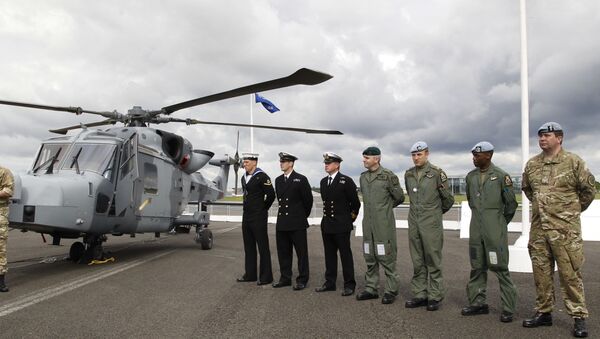 British forces' personnel stand to attention in front of a new AgustaWestland AW159 Wildcat helicopter at the Farnborough International Airshow in Farnborough, England (file) - Sputnik Việt Nam
