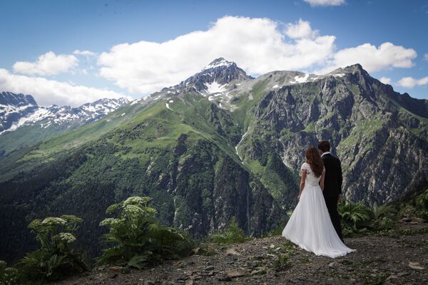 Cặp vợ chồng mới cưới thưởng thức vẻ đẹp của khu nghỉ mát vùng núi Dombai (Nga, Bắc Kavkaz) - Sputnik Việt Nam
