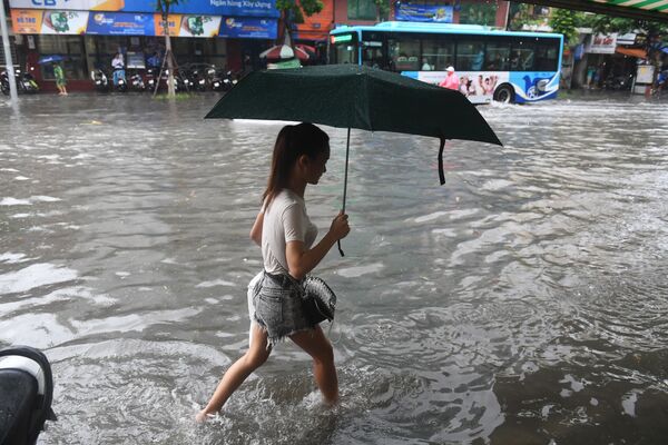 Người đi bộ ở Hà Nội bị ngập nước do bão nhiệt đới Talas - Sputnik Việt Nam