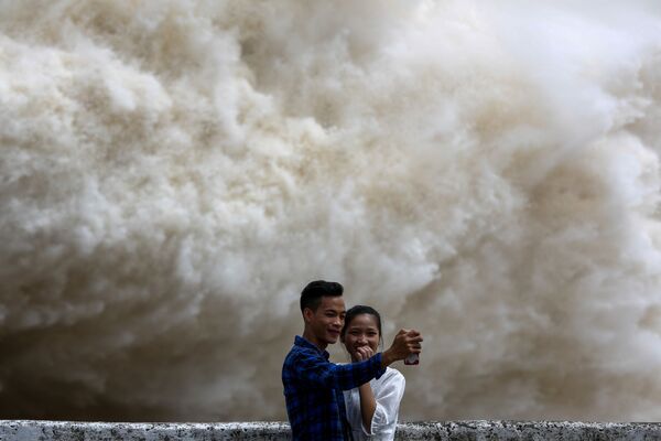 Cặp đôi đang chụp ảnh trên nền nhà máy thủy điện Hòa Bình xả nước - Sputnik Việt Nam